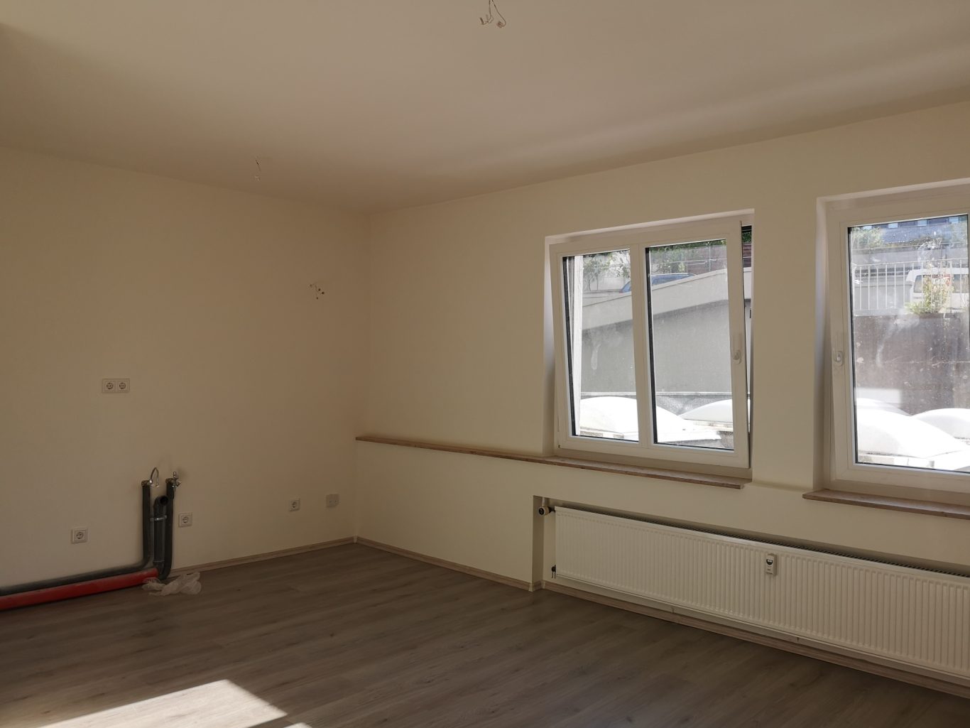 Immobilienmakler Münster Heller, leerer Raum mit Fenstern und Holzfußboden, unmöbliert.