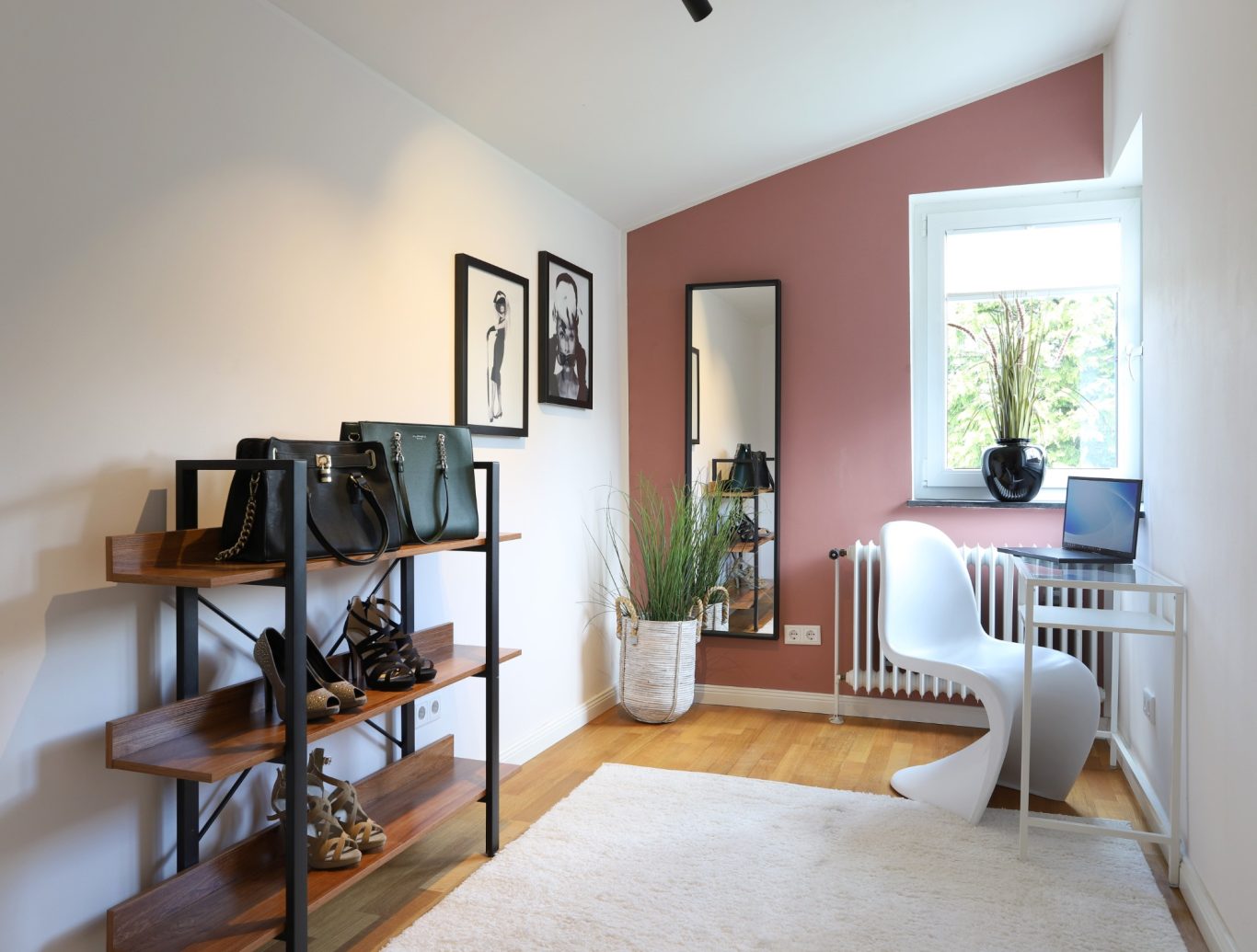 Immobilienmakler Münster Heller Raum mit Kommode, Schreibtisch, Pflanzen und modischer Dekoration.