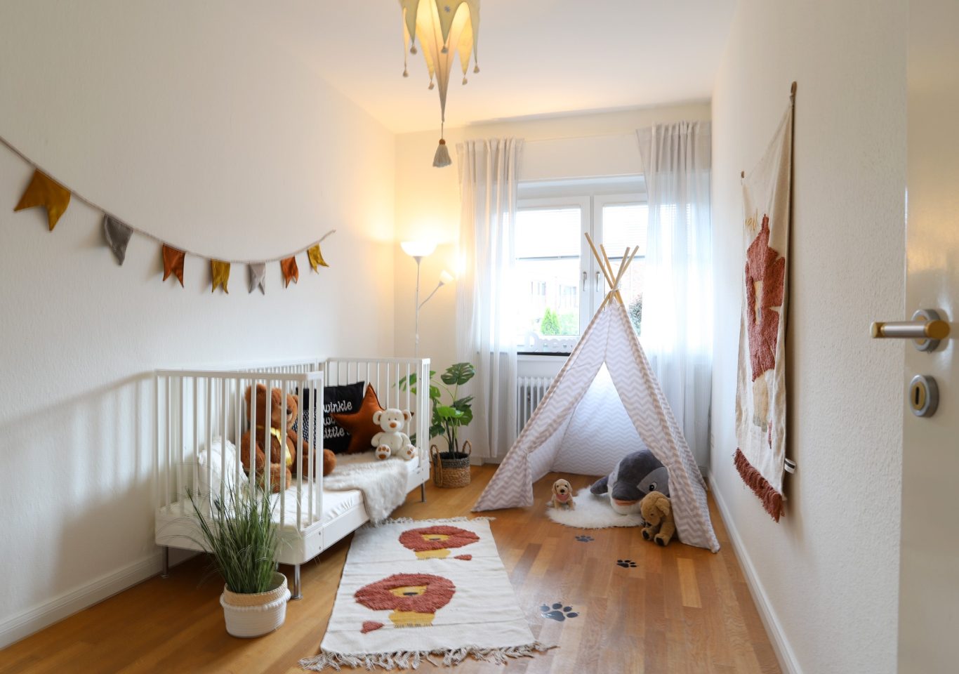 Immobilie mit Kinderzimmer Kinderzimmer mit Zelt, Teppichen und Pflanzen, in warmen Farben eingerichtet.